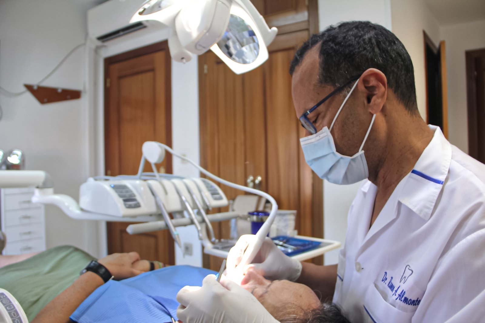 Doctor Ramón Almonte preparando sus instrumentos para tratamientos dentales en su clínica dental